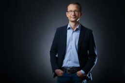 lockeres Bewerbungsbild mit dunkelm Hintergrund